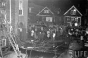 The crowd in Avers Avenue remains large well after the fire is out and most victims have been removed. Looking west in the alley between the school and Glowacki's candy store. (Life Magazine Photo)