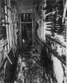 This is the narrow passage between the north wing and the annex. In this view looking from the north wing main hallway toward the annex, the staircase in the annex is visible beyond the doorway. This door was closed early in the fire, preventing fire from entering the annex and south wing.
