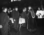 Monsignor Cussen offers a blessing over the coffin of a victim after the Mass at the Northwest Armory. (Photo courtesy of The Catholic New World with photo research by Renee Jackson)