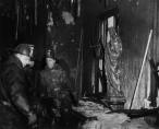 When firemen were finally able to enter the school, to their horror they discovered their mission had become one of recovering bodies, for all who remained were dead. Here firemen work in the front hall of the north wing, as a blackened statue of Christ looks on. (Photo courtesy of The Catholic New World with photo research by Renee Jackson)