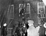 Another view of firemen carefully lowering Joseph Maffiola down from room 212. Joseph and 25 of his classmates and their teacher died from smoke inhalation in room 212.