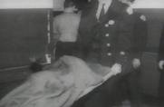 The badly burned body of a child is removed from the school. Many children in the classrooms died from asphyxia in the suffocating smoke and super heated gases.