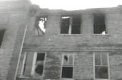 Looking from the alley up to the windows of room 208, where the roof collapse is plainly visible through the windows. Although room 208 was closest to the source of the fire (the stairwell to the left), most of the children escaped from this room, thanks to assistant janitor Mario Camerini who placed the church's only extension ladder at one of these windows.
