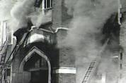 Firemen attempt to gain access to the second floor where dozens of children are still trapped in their classrooms. Entering via the stairwells is hopeless at this point because of the suffocating smoke. In 1958, firefighters did not have masks and air bottles.