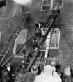 Firemen carefully retrieve the body of a young girl from room 212, before the fire is completely extinguished.